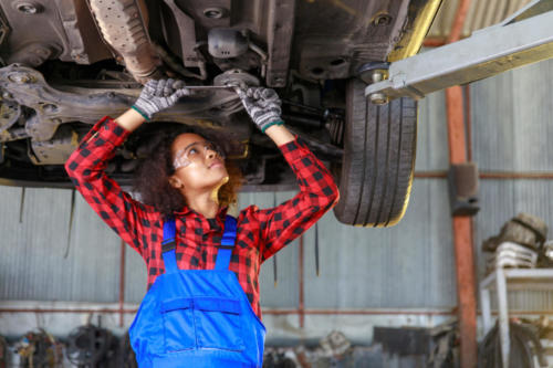 Female auto mechanic working at the repair shop.