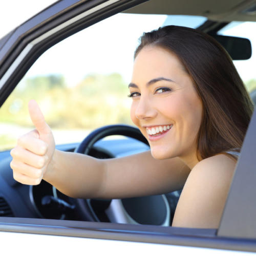Satisfied driver with thumbs up in a car